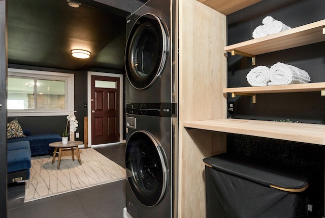 washroom with tile patterned floors, laundry area, and stacked washer and dryer