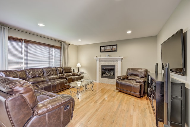living area with recessed lighting, a fireplace, and light wood finished floors