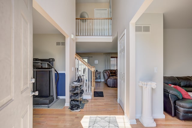 foyer featuring visible vents, wood finished floors, and stairway