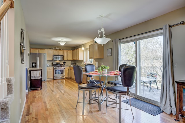 dining area featuring light wood-style floors and baseboards