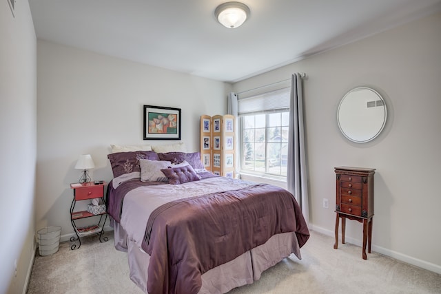 bedroom featuring baseboards, visible vents, and light carpet