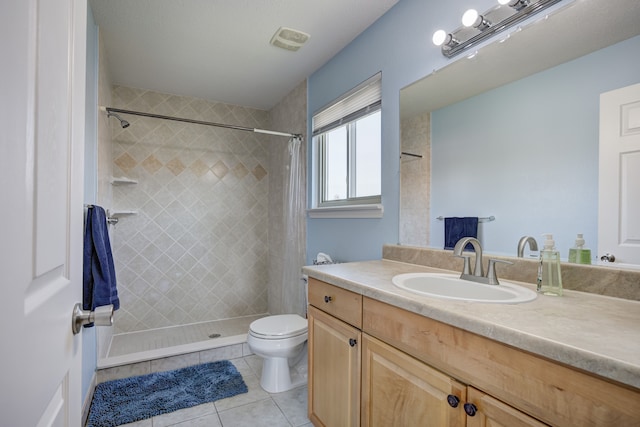 full bathroom with tile patterned flooring, visible vents, vanity, toilet, and a tile shower