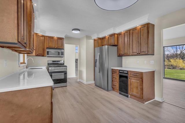 9315 Kingsley Dr, Onsted, MI 49265 - kitchen featuring brown cabinetry, stainless steel appliances, light wood-style floors, light countertops, and a sink