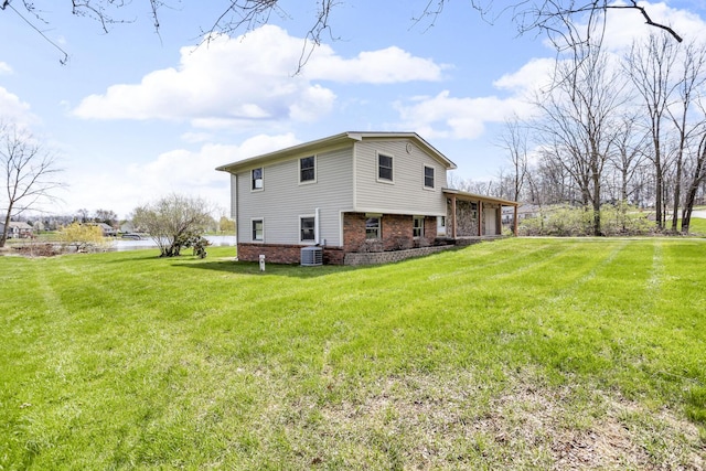 9315 Kingsley Dr, Onsted, MI 49265 - rear view of house featuring brick siding, cooling unit, and a lawn
