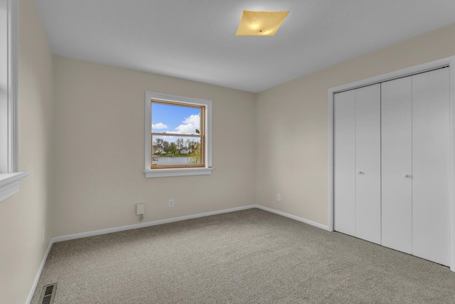 9315 Kingsley Dr, Onsted, MI 49265 - unfurnished bedroom featuring baseboards, visible vents, carpet floors, and a closet
