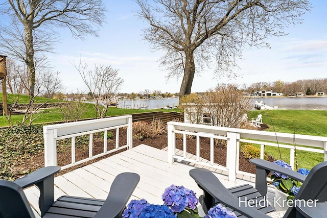 wooden deck with a yard and a water view