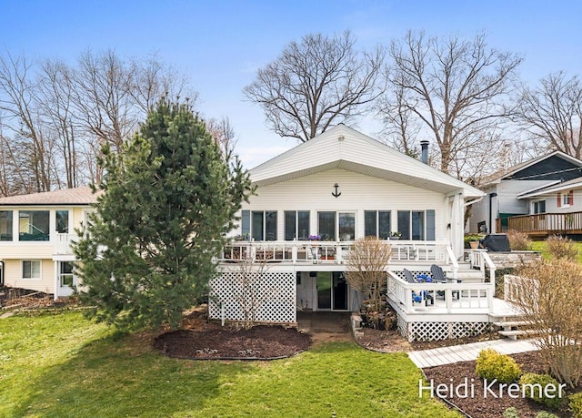 rear view of house with a lawn and a deck