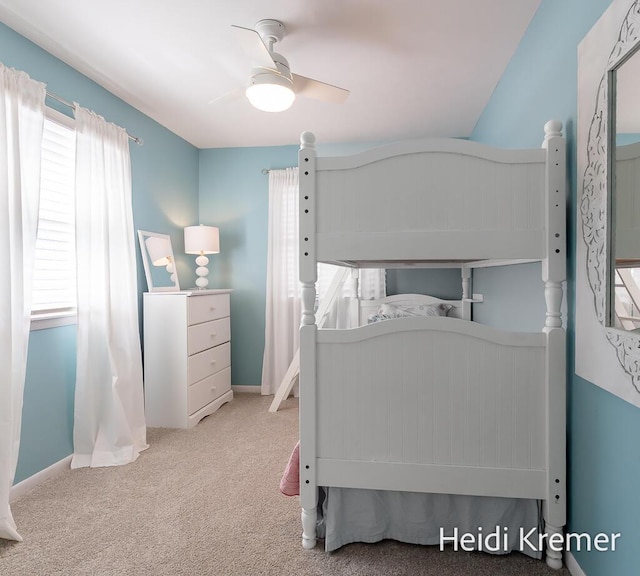 carpeted bedroom with multiple windows, ceiling fan, and baseboards