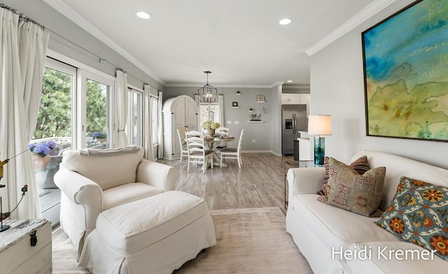 living room featuring ornamental molding, recessed lighting, an inviting chandelier, and light wood-type flooring