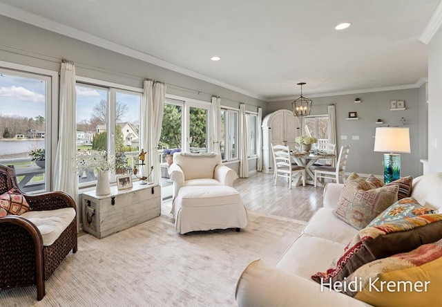 living room featuring a chandelier, recessed lighting, ornamental molding, and light wood-style floors