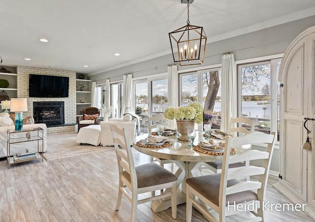 dining room with a notable chandelier, a wealth of natural light, a water view, and crown molding