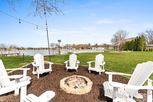view of yard with an outdoor fire pit and a water view