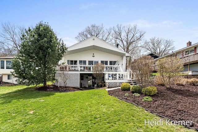 back of property featuring a wooden deck and a yard
