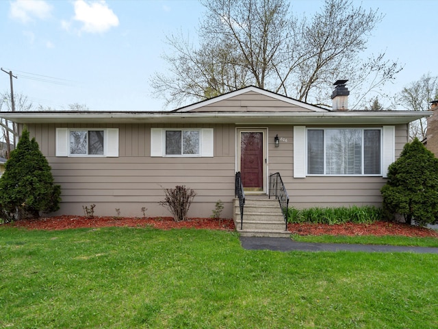 view of front facade with a chimney, board and batten siding, entry steps, and a front yard