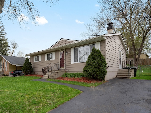 view of front of house with a chimney, fence, and a front yard