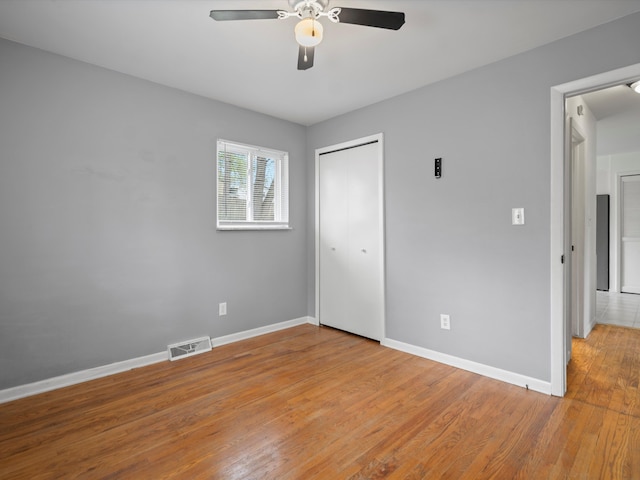unfurnished bedroom with baseboards, visible vents, light wood-type flooring, and a closet