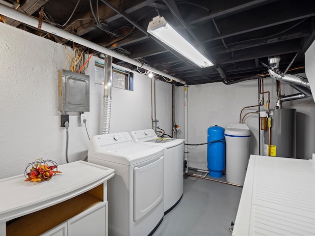 washroom with gas water heater, washing machine and dryer, electric panel, laundry area, and a textured wall