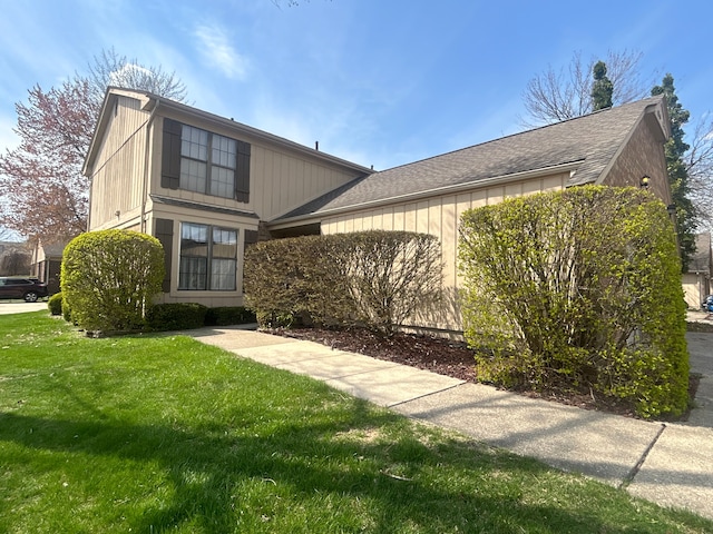 view of front of home with a shingled roof and a front lawn