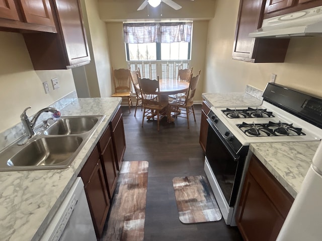 kitchen featuring a sink, gas stove, dishwasher, dark wood-type flooring, and under cabinet range hood