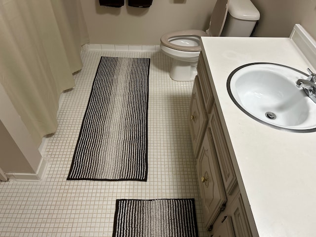 bathroom featuring vanity, tile patterned floors, and toilet
