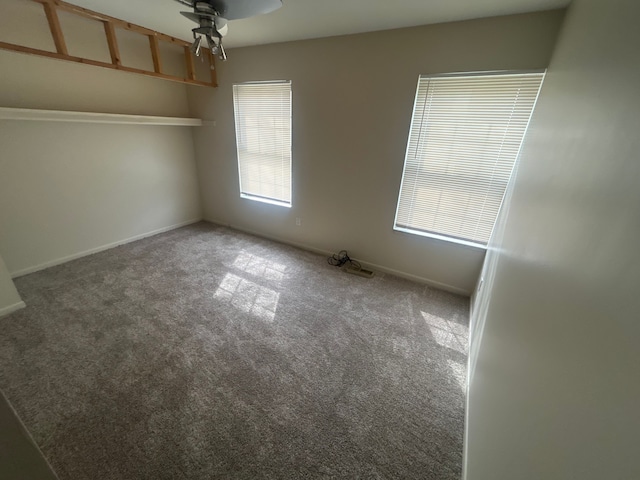 empty room with baseboards, a ceiling fan, and carpet