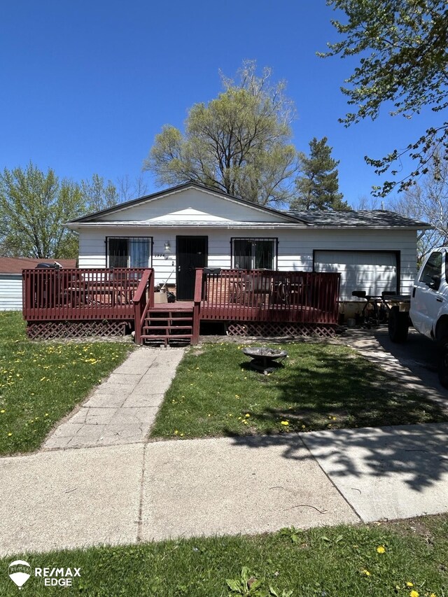 1934 Basil Ln, Flint, MI 48504 - view of front of house featuring an attached garage, a front yard, and a wooden deck