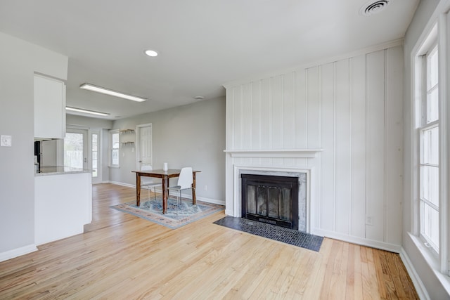unfurnished living room with visible vents, a fireplace, baseboards, recessed lighting, and light wood-style flooring