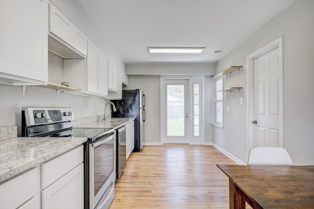 kitchen featuring open shelves, a sink, stainless steel appliances, white cabinetry, and light wood-type flooring