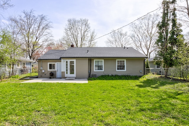 rear view of house with a lawn, a chimney, a fenced backyard, and a patio area