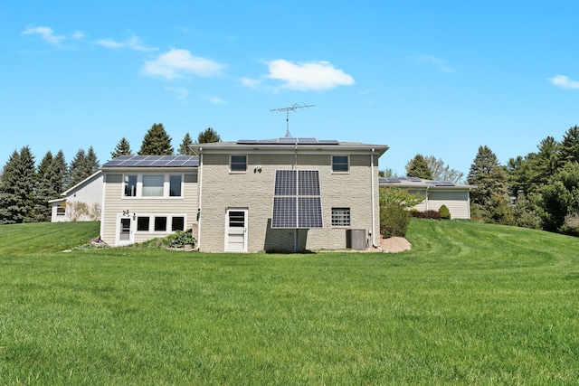 5480 Kensington Rd, Brighton, MI 48114 - rear view of property featuring roof mounted solar panels, a yard, central AC unit, and brick siding