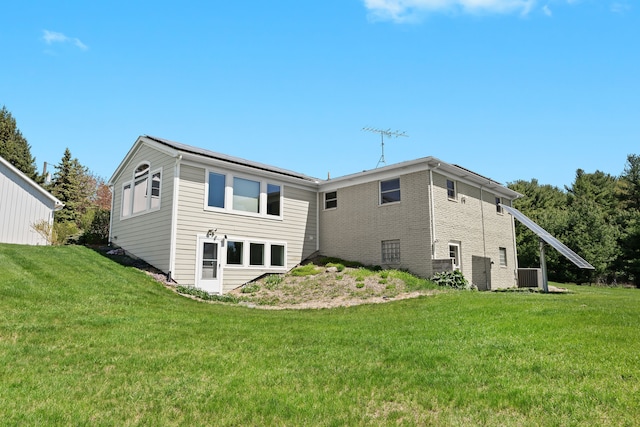 5480 Kensington Rd, Brighton, MI 48114 - rear view of property featuring a yard, brick siding, and central AC