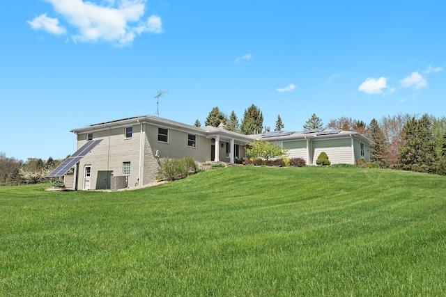 5480 Kensington Rd, Brighton, MI 48114 - back of property with solar panels, a yard, and brick siding