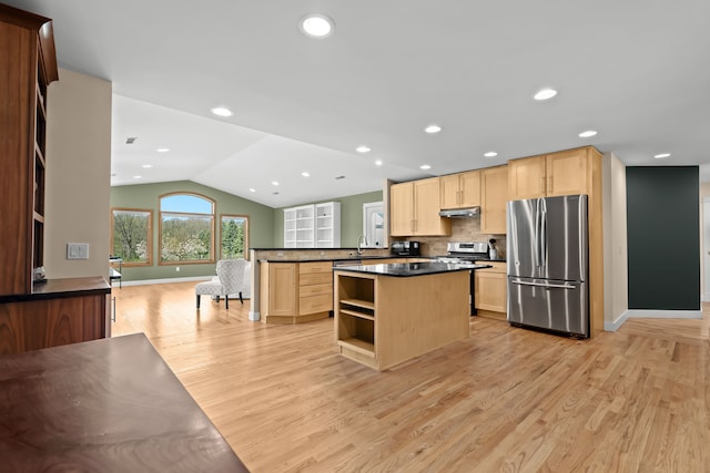 5480 Kensington Rd, Brighton, MI 48114 - kitchen featuring appliances with stainless steel finishes, light brown cabinetry, dark countertops, light wood finished floors, and lofted ceiling