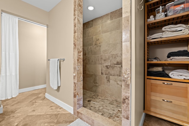 5480 Kensington Rd, Brighton, MI 48114 - full bathroom with walk in shower, a spacious closet, baseboards, and stone finish flooring