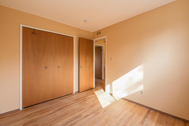 3134 Williamsburg Rd, Ann Arbor, MI 48108 - unfurnished bedroom featuring a closet, visible vents, and light wood-style flooring