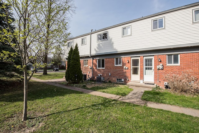 3134 Williamsburg Rd, Ann Arbor, MI 48108 - back of property featuring central AC, brick siding, and a yard