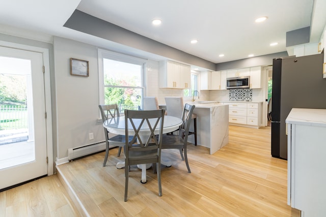 dining space featuring recessed lighting, light wood-style flooring, and a baseboard heating unit