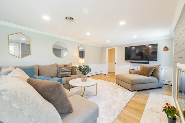 living room with light wood-style floors, a baseboard radiator, baseboard heating, and visible vents