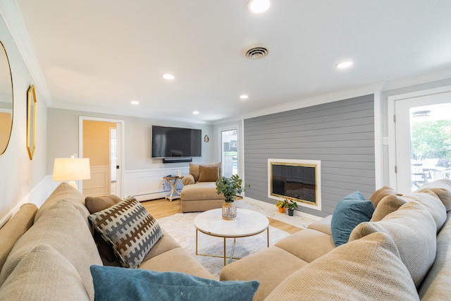 living area featuring crown molding, visible vents, a wealth of natural light, and wood finished floors