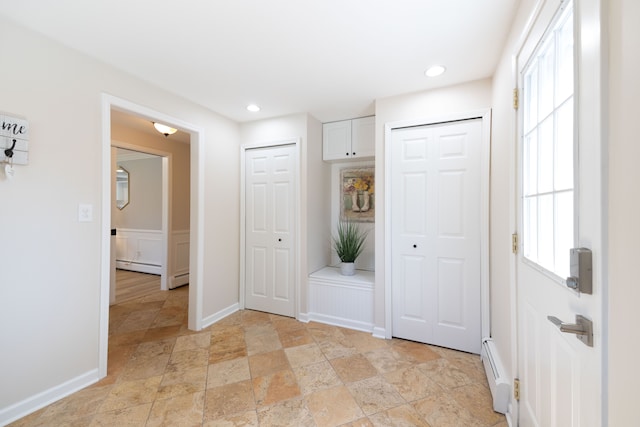 interior space with baseboard heating, stone tile floors, recessed lighting, baseboards, and a baseboard heating unit