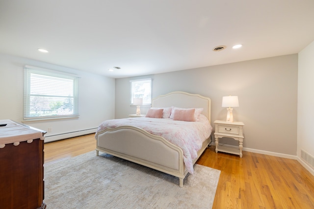 bedroom with baseboard heating, light wood-style flooring, recessed lighting, baseboards, and visible vents