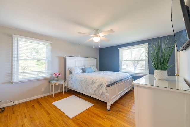 bedroom featuring a ceiling fan, baseboards, and light wood-style flooring
