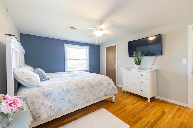 bedroom with a ceiling fan, baseboards, visible vents, and light wood finished floors