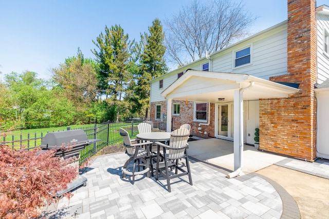 view of patio featuring grilling area, fence, and outdoor dining space