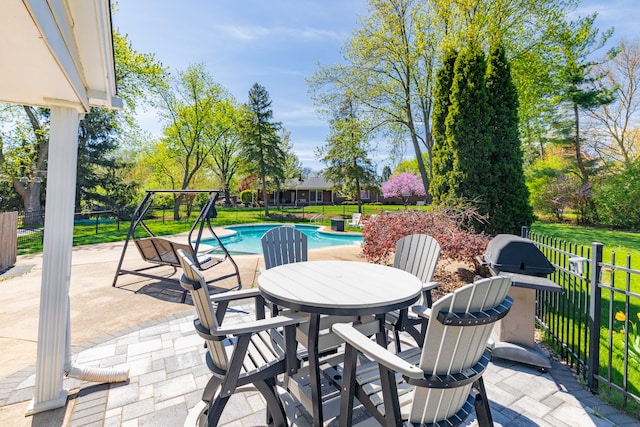 view of patio with fence, a fenced in pool, and outdoor dining area