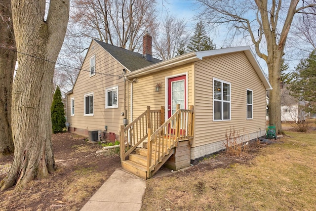 1743 Midland Rd, Bay City, MI 48706 - view of front of home featuring central AC unit, a chimney, roof with shingles, and a front yard