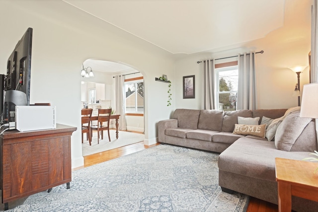 1743 Midland Rd, Bay City, MI 48706 - living area featuring arched walkways, wood finished floors, and a chandelier
