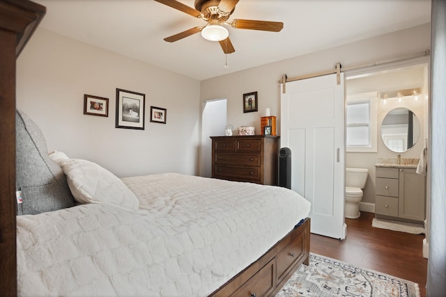 1743 Midland Rd, Bay City, MI 48706 - bedroom with dark wood-style floors, a barn door, connected bathroom, and a ceiling fan