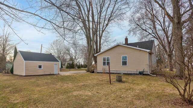 1743 Midland Rd, Bay City, MI 48706 - view of home's exterior with a chimney, an outbuilding, and a lawn