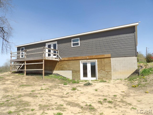 7640 S Lake Pleasant Rd, Osseo, MI 49266 - back of property with french doors and a wooden deck